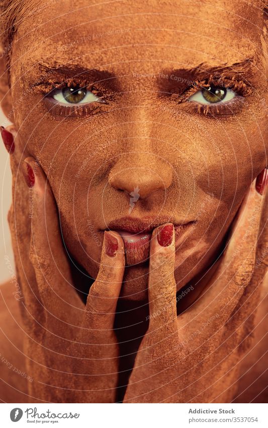 Weibliches Modell mit Schokolade im Gesicht Frau Pulver Gesicht berühren Konzept Deckung Leckerbissen sinnlich Vorschein jung schön Menschliches Gesicht