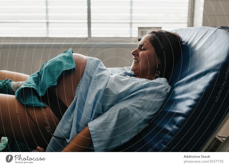 Frau, die im Krankenhaus entbindet Geburt Baby Schmerz Grunzen packen Stuhl Arzt modern Handgriff medizinisch Pflege geduldig Gesundheitswesen Medizin