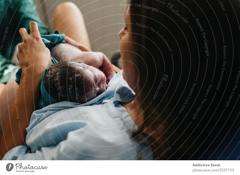 Glückliche Mutter umarmt Neugeborenes Baby Umarmung neugeboren Geburt Krankenhaus Versand Raum modern Frau Blut heiter Kind Säugling Zeitgenosse Pflege Eltern
