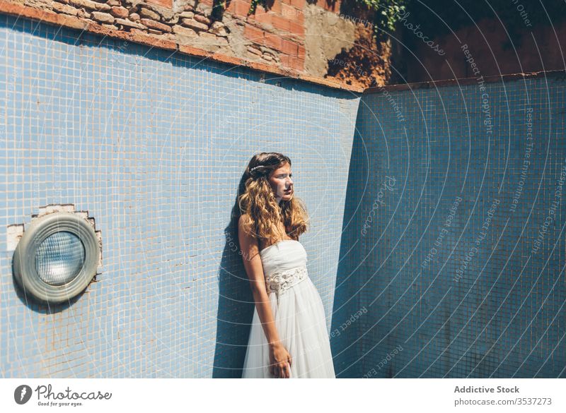 Sinnliche junge Braut in stilvollem weißen Brautkleid im leeren Pool stehend Frau Kleid elegant sinnlich romantisch blond Sommer Hochzeit allein schäbig Stil