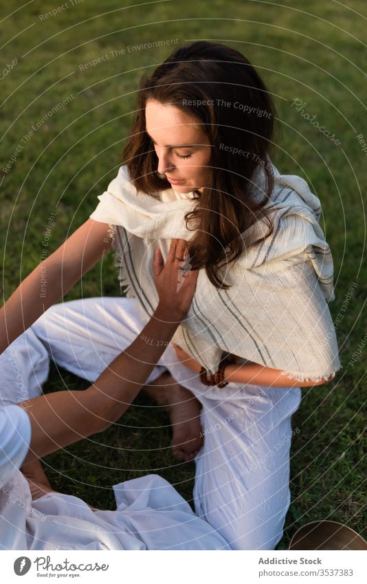 Liebespaar macht Partner-Yoga in der Natur Paar gegenüber meditieren Lotus-Pose Windstille Zen Herz Rasen Lotos Augen geschlossen Magen genießen grün