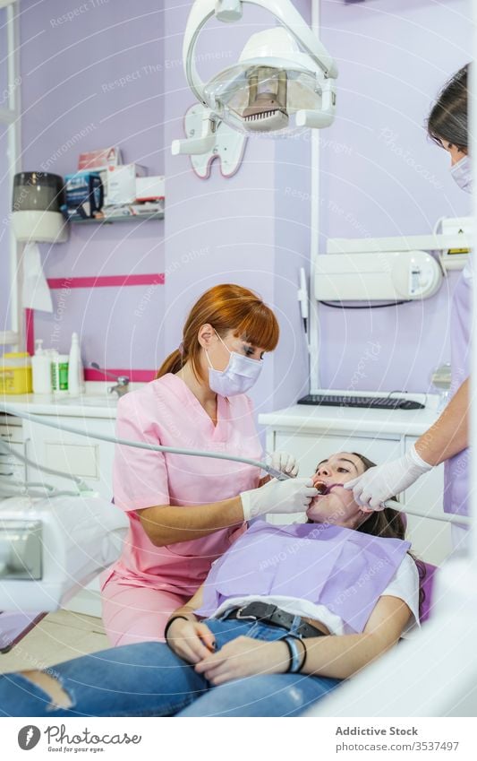 Zahnärztin mit Assistentin heilt Patientenzähne in der Klinik Zahnarzt Frauen geduldig Zähne Mundschutz dental Arzt Stomatologie Uniform Medizin Leckerbissen