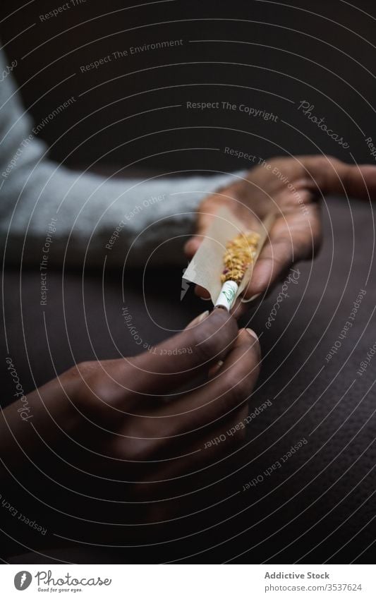 Anonyme ethnische Person rollt Unkraut auf hochkrempeln Inder Marihuana ganja Vergnügen ungesund stumpf friedlich genießen Zigarette Betäubungsmittel Medikament