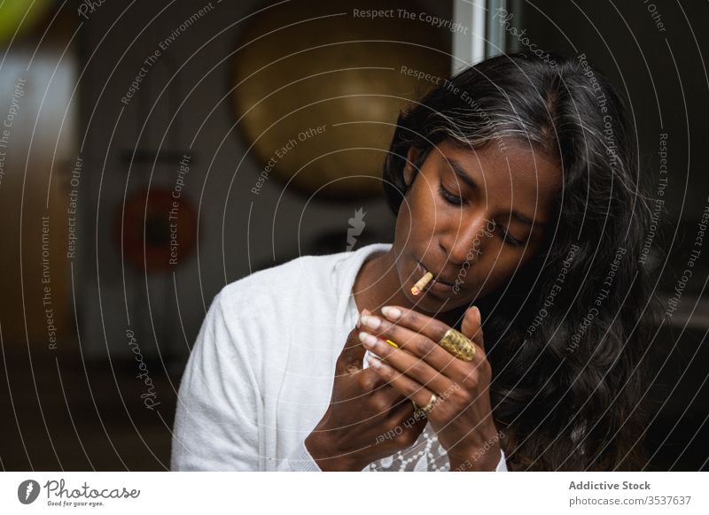 Ethnische Frau raucht Gras auf der Terrasse Rauch Marihuana Unkraut sich[Akk] entspannen genießen hochkrempeln jung Zigarette ethnisch Inder hinduistisch lässig