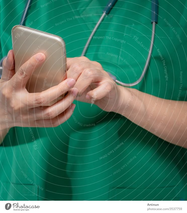 Arzt mit Stethoskop benutzt Mobiltelefon zur Kommunikation mit Gesundheitsdienstleistern oder Patienten. Chirurg hält Smartphone in der Hand. Medizinische Gesundheitsanwendung auf Mobiltelefon. Telemedizinisches Konzept.