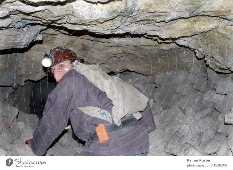 Ein Bergmann, der durch einen gefährlich instabilen Schacht einer Mine in Cerro Rico kriecht. Bolivien bolivianisch cerro rico Kohle Gefahr gefährlicher Beruf