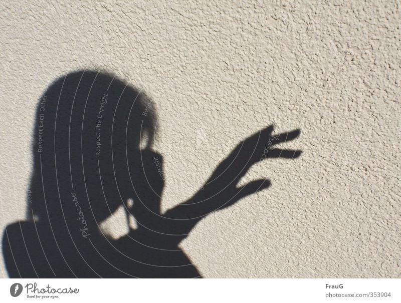 Schattenspiele feminin Frau Erwachsene Kopf Hand Finger 1 Mensch 45-60 Jahre Schönes Wetter Fassade schwarz Fotografieren zeigen Außenaufnahme Textfreiraum oben