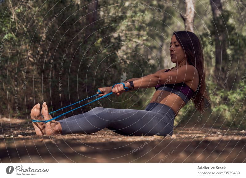 Starke Frau trainiert mit Fitnessgummiband im Wald stark Übung Sportlerin Gummi Band Training Natur Expander ziehen Gesundheit Wellness passen Wohlbefinden