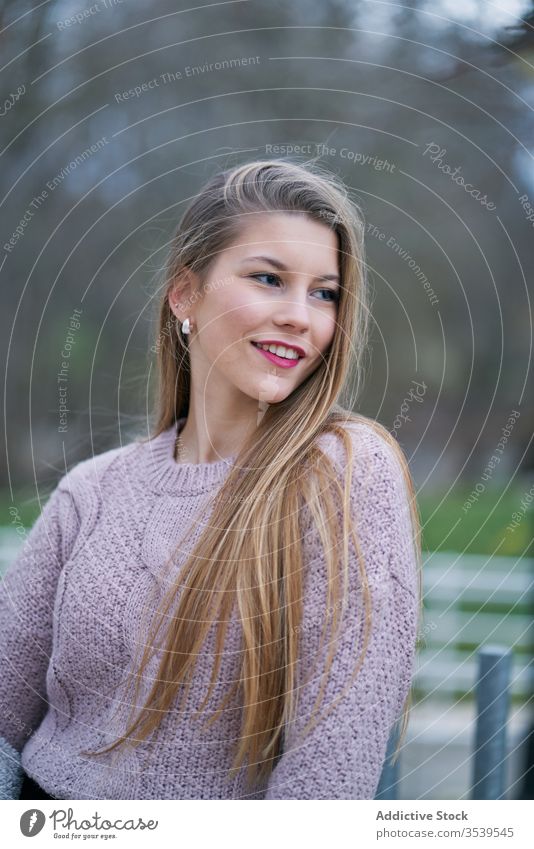 Positive junge Studentin mit wallendem Haar im Park Frau Lächeln Individualität Art positiv Stimmung Persönlichkeit Porträt Glück Spaziergang Pflege verträumt