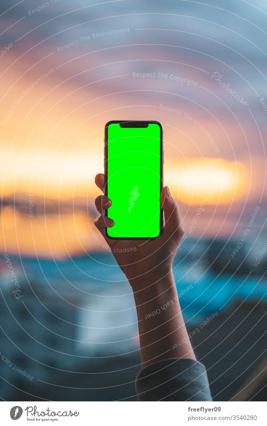 Hand, die ein Smartphone auf einem grünen Bildschirm hält Telefon Foto Fotografie Fotografieren Technik & Technologie Schuss klug benutzend Mobile Handy unter
