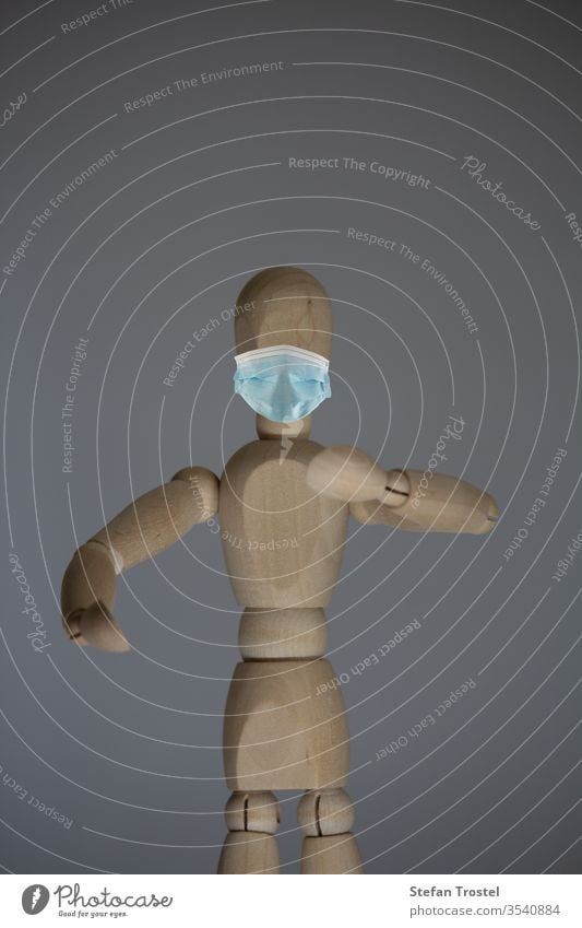 Holzstatue mit Mund- und Nasenmaske, als Schutz gegen Viren Porträt Puppe Körper Konzept Holzarbeiten Hintergrund Pose Kunstturnen Marionette Design Model