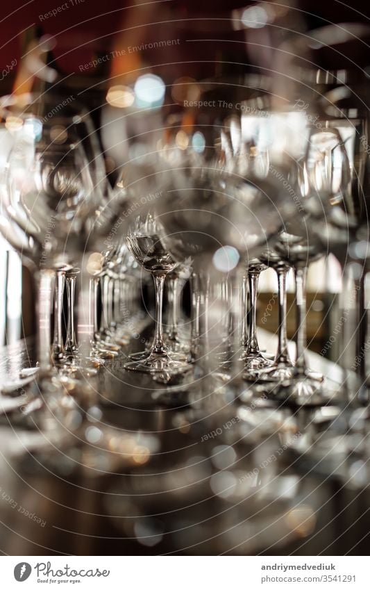 leere Weingläser. Schöne neue Gläser für Wein aus Glas stehen in gleichmäßigen Reihen auf einem Holztisch in einem Restaurant. selektiver Fokus Alkohol Bar