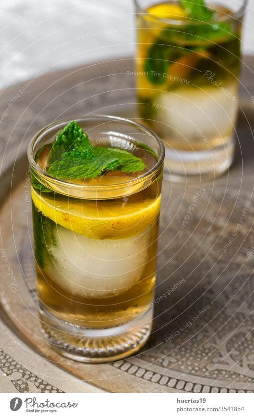 Erfrischende Teegläser mit Eis, Minze und Zitronenspalten kalt trinken eisbedeckt Glas Erfrischung süß Würfel cool liquide Hintergrund Getränk Sommer