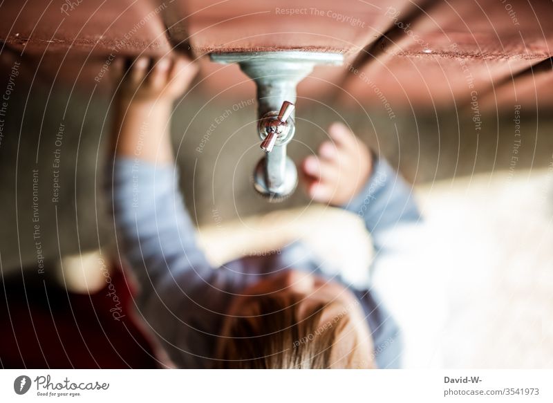Jungen und Technik - Faszination Kind Kleinkind Garten Wasserhahn Wassertropfen beobachten niedlich wasserknappheit Dürre betrachten zu Wand Holzwand erkunden