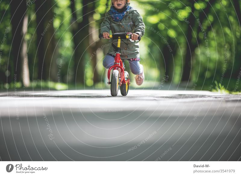 Kind fährt mit dem Fahrrad draußen durch die Natur Kindheit Freude Fahrradfahren klein Kleinkind Mädchen niedlich schnell Kinder Lächeln Mund Lenker festhalten