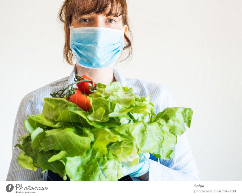 Frau in Blau in Gesichtsmaske mit frischen Produkten Mundschutz Lebensmittel Versand Lebensmittelgeschäft Bauernhof produzieren Ladenbesitzer Notwendigkeiten