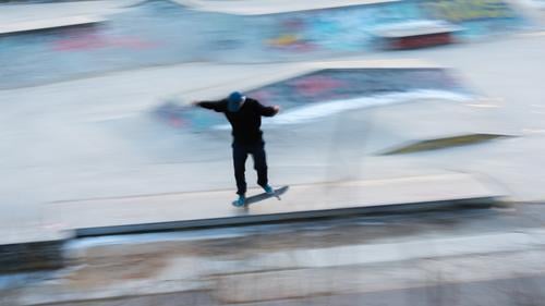 Ein Eiskunstläufer in Bewegung bei einem Stunt Aktion aktiv Aktivität Kunst fantastisch Gleichgewicht Berlin Unschärfe-Effekt verschwommen Holzplatte Großstadt