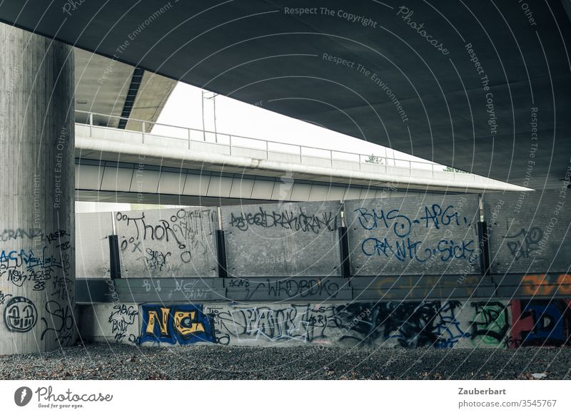 Kreuzende Autobahnen mit Betonpfeiler, Brücken, Sichtschutz und Graffiti Pfeiler Grafitti grau Kreuzung Auffahrt elegant symmetrisch technisch Verkehr