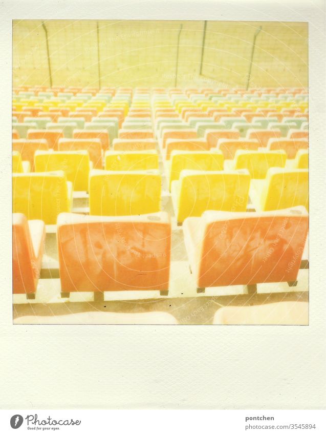 Polaroid. Bunte Sitze in einem Stadion. Sportstätte.,Fußball. Rasen bunt sitze Sitzplätze polaroid orange gelb Grün rasen sportstätte fußball alt vergangenheit