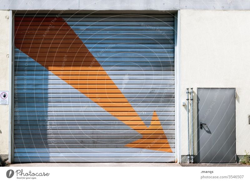 Da ist die Tür! Rolltor Rollladen Pfeil Hinweis Gebäude orange grau groß überdimensioniert geschlossen Kündigung rauswurf Trennung