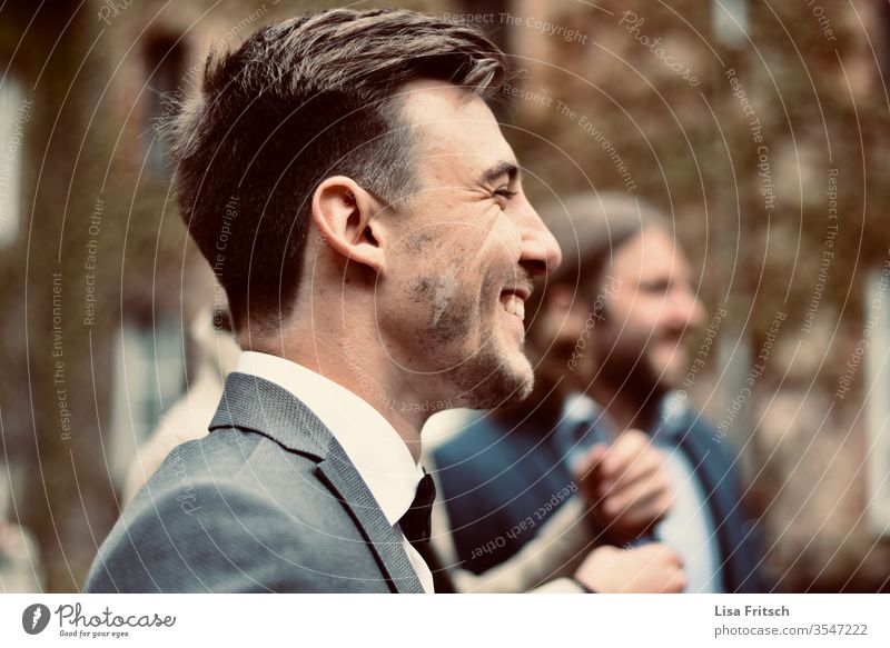 Mann - glücklich - lachen - genießen 18-30 Jahre brünett Anzug Anzugträger Bart Lachfalte hübsch Freude Gast Hochzeit Spaß haben gemeinsam grau Junger Mann
