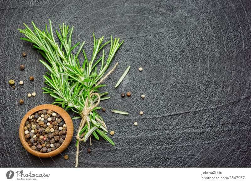 Gewürze und Kräuter über schwarzem Steintisch Rosmarin Bestandteil frisch Kraut roh organisch Essen zubereiten Lebensmittel grün Küche Pflanze Natur Gesundheit