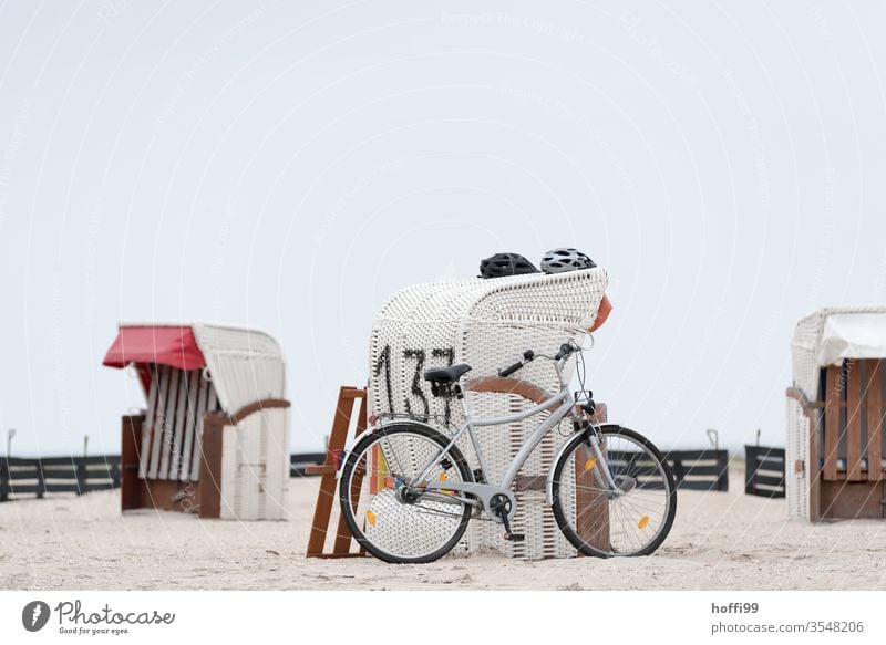 Strandkorb, zwei Helme ein Fahrrad am Meer Küste Nordsee Ostsee Sand Sonne Tourismus Erholung Insel Himmel Ferien & Urlaub & Reisen Sommer Sommerurlaub Ausflug