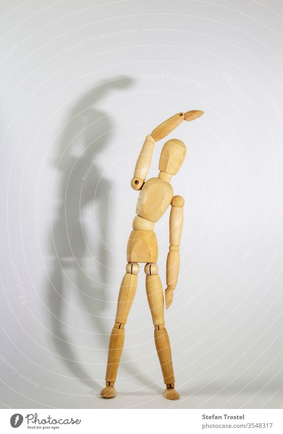 Holzpuppe während der Yogapraxis Ansanas, Dreieck Trikonasana, vor weißem Hintergrund Puppe Körper Dummy Gleichgewicht Figur Fitness gestikulieren Probe Model