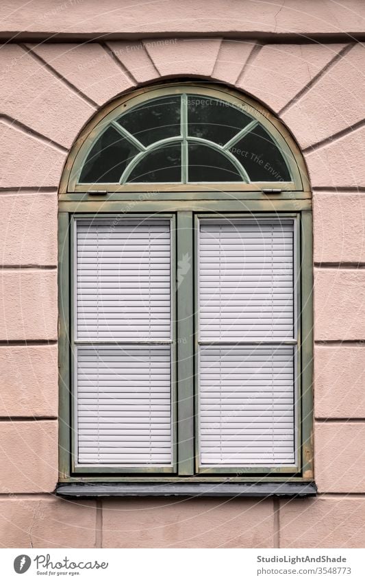 Rosa Gebäude mit abgerundetem grünen Fenster Rahmen rosa staubig-rosa Pastell Haus Wand Privatsphäre privat zugeklappt Jalousien Gardine Schatten Europa