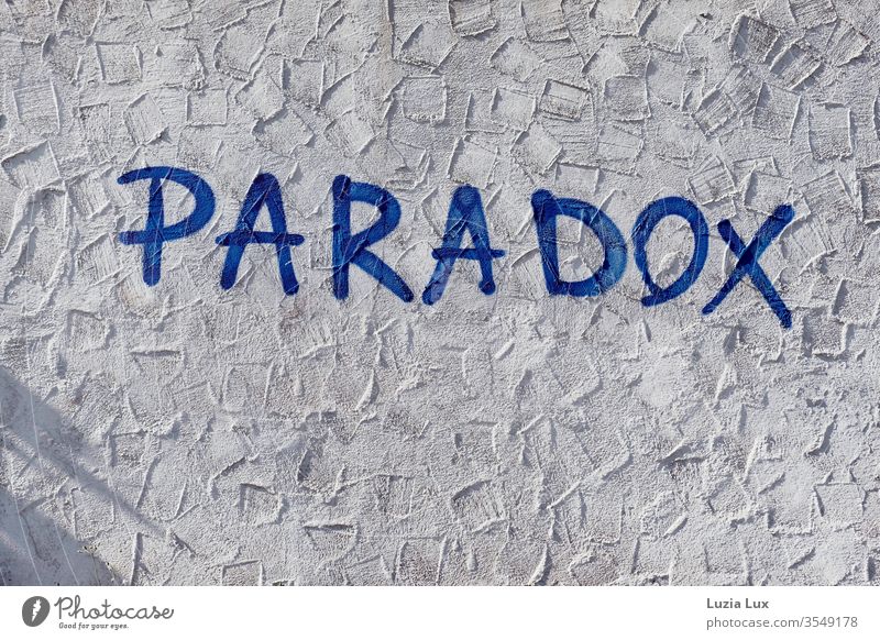 Paradox - Graffiti an einer Mauer mit Putz, Sonnenlicht und Schatten Wand Straße Tristesse Stadt urban Außenaufnahme Menschenleer Tag Fassade Wege & Pfade