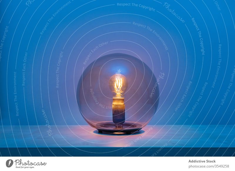 Eingeschaltete Kugellampe in dunklem Raum Lampe Glas Ball Regal Glühbirne dunkel elektrisch blau Design Leuchte Dekoration & Verzierung modern antörnen Stil