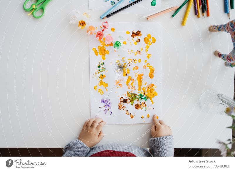 Fokussiertes blondes Kind benutzt Gouache zum Fingermalen zu Hause Junge Farbe zeichnen kreativ heimwärts Kindergarten kleben Zeichnung Papier wenig niedlich