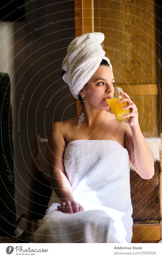 Verträumte junge Frau sitzt im Handtuch und trinkt Fruchtsaft trinken Saft Morgen nass Dusche Kälte Harmonie nachdenken verträumt sich[Akk] entspannen ruhen
