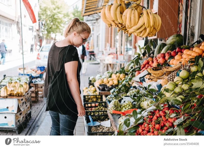 Frau wählt Früchte auf dem lokalen Markt Frucht Abfertigungsschalter Basar Straße farbenfroh wählen Ware erkunden Spaziergang Großstadt Lifestyle Käufer kaufen