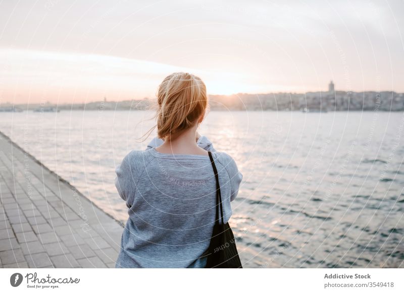 Junge Frau bewundert Blick auf Sonnenuntergang Ansicht Podest beobachten Reflexion & Spiegelung MEER Spazierweg rosa Licht Windstille horizontal Reisender Ufer