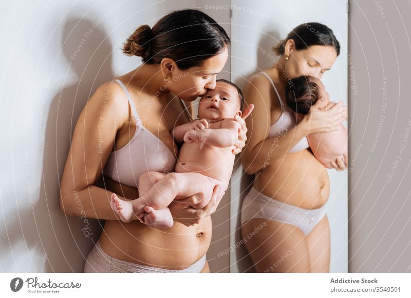 Fröhliche Mutter und Kleinkind im Wohnzimmer Säugling kuscheln Unterwäsche Baby heiter Freude Lächeln Spiegel Zusammensein Mama Mutterschaft Eltern Elternschaft