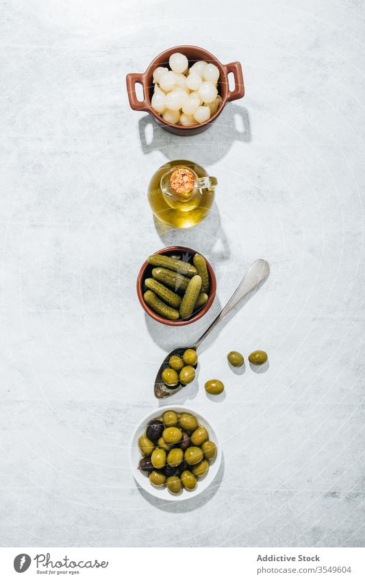 Schalen mit Snacks und Glasgefäß mit Olivenöl oliv Erdöl Pickles Schalen & Schüsseln Salatgurke Tisch Reihe eingelegt extra jungfräulich Kannen Löffel Küche