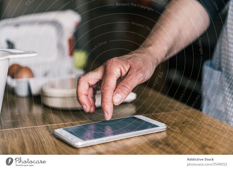 Hausfrau liest Rezept auf Smartphone Frau Küche benutzend backen vorbereiten Bestandteil Tisch Koch Hand reif Abfertigungsschalter Gerät Apparatur heimwärts