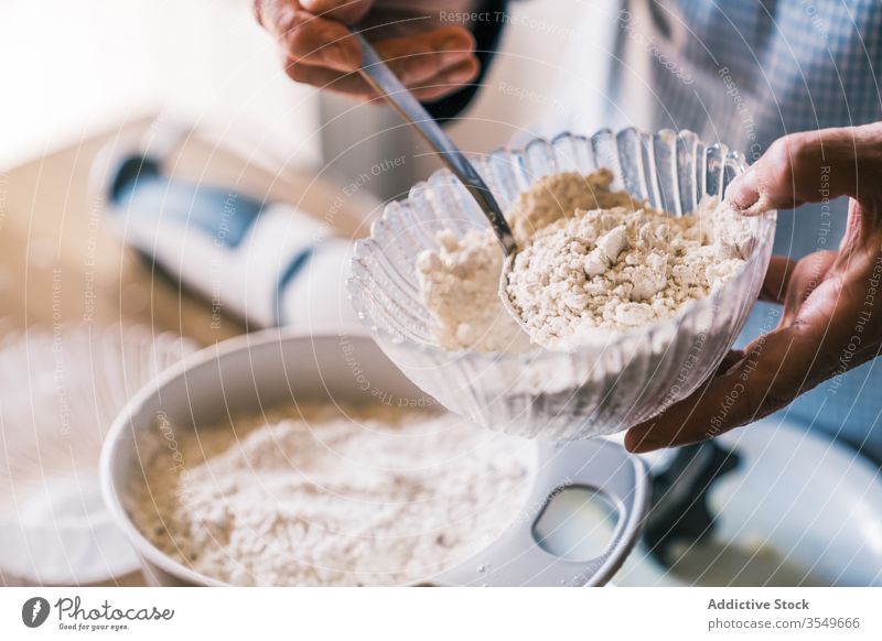 Oberkoch gießt Mehl in der Küche in eine Schüssel eingießen Teigwaren hinzufügen Koch Konditor vorbereiten Muffin Senior Schalen & Schüsseln Schürze Glas Löffel