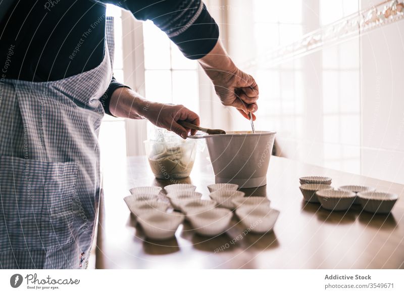 Ältere Frau mischt Teig für Muffins mischen Teigwaren Muffin-Gehäuse Küche Konditor Schürze gealtert Koch vorbereiten Senior Schalen & Schüsseln Kunststoff