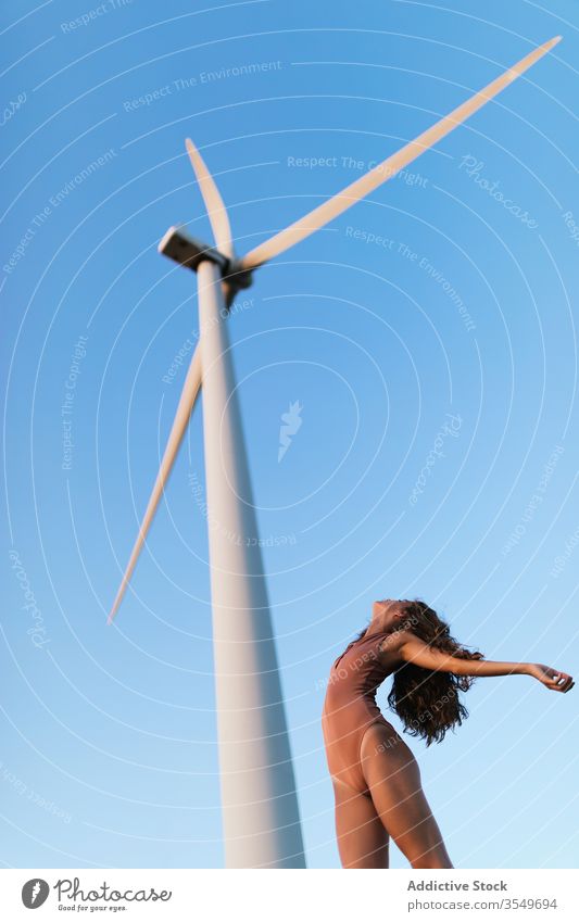 Junge schlanke Dame tanzt an einem sonnigen Tag unter einer Windmühle Frau Body Tanzen Harmonie beweglich Ökologie Natur Umwelt allein hochreichen ausführen