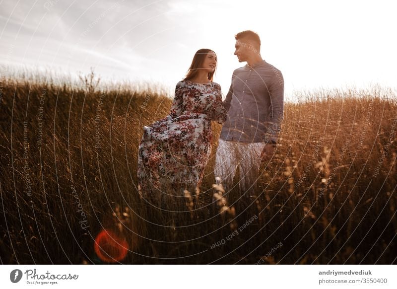 junges Paar, das sich in der Natur auf einem Feld ausruht. Paar bei Sonnenuntergang Sommer Partnerschaft ruhen Mann romantisch Liebe Lifestyle Landschaft Glück