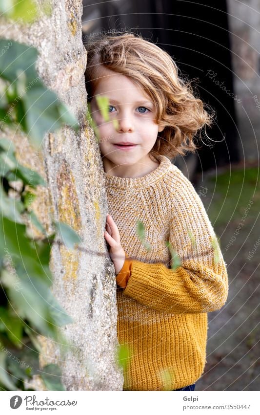 Glückliches blondes Kind mit langen Haaren im Freien Junge Kindheit außerhalb Baum Tierhaut Park niedlich weiß Porträt wenig Kaukasier Menschen jung Lächeln