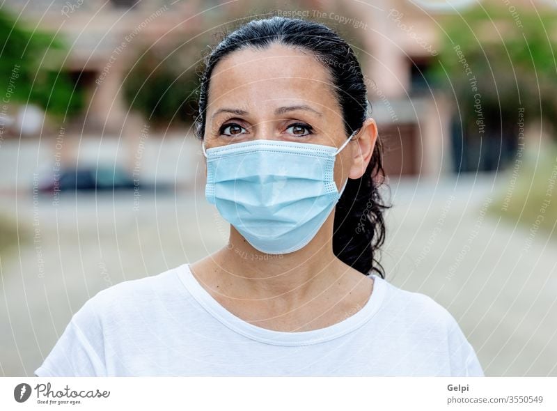 Brünette Frau mit Maske Schutz Straße Mundschutz Gesicht im Freien Korona Gesundheitswesen covid-19 Coronavirus Grippe Großstadt Pandemie Mädchen medizinisch