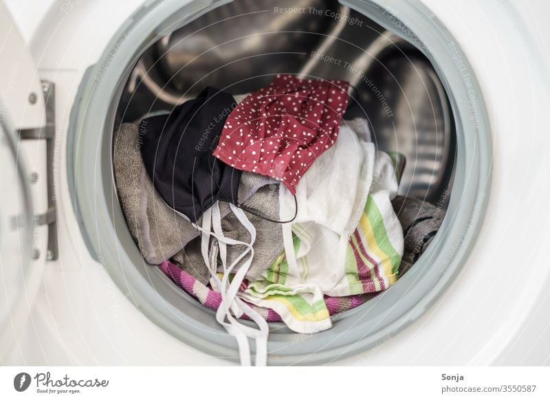 Mundschutz in einer Waschmaschine, Hygiene, Desinfektion Sauberkeit Wäsche waschen Gesundheit Corona-Virus Bakterien Prävention Schutz Infektion Pandemie