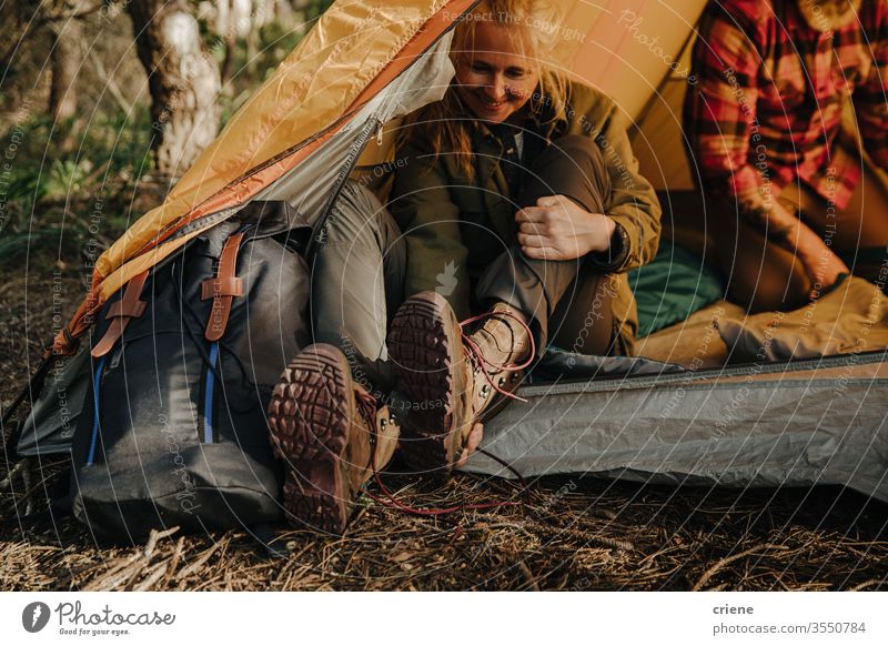 Ältere Frau zieht Wanderschuhe aus und sitzt im Zelt Beine Schuhe genießend aktiv Rucksacktourismus Aktivität Tourist Freizeit Feiertag Senioren reisen Natur