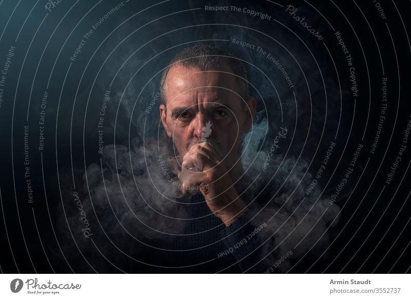 Porträt eines Mannes mit Verdampfer und Rauch Hintergrund Vollbart schwarz blasend Unschärfe Zigarette Zigaretten selbstbewusst cool E-Zigarette ecig