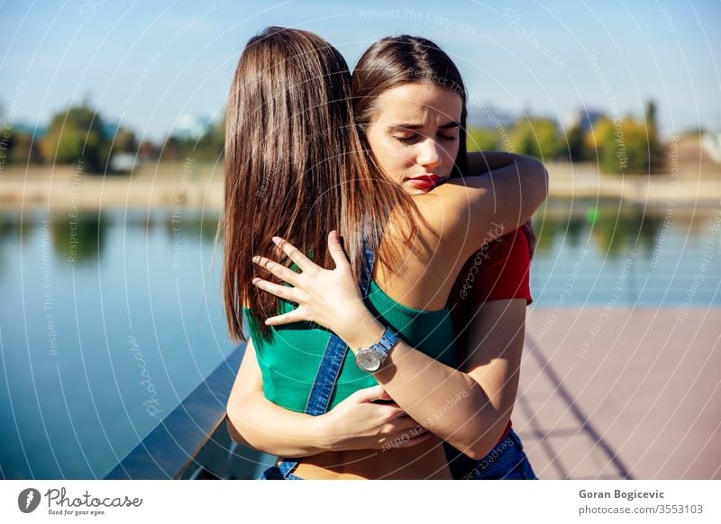 Junge Frau umarmt und unterstützt ihre beste Freundin schön Menschen Wasser Kaukasier Person Umarmung jung Traurigkeit Einsamkeit hübsch Umarmen Natur Liebe