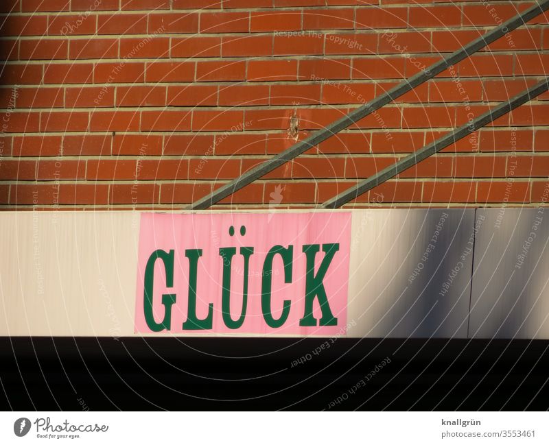 Werbung, das Wort „GLÜCK“ über einem Einzelhandelsgeschäft angebracht Glück Schriftzeichen Typographie Buchstaben Schilder & Markierungen Hinweisschild Text