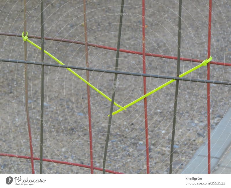 Roter und schwarzer Bauzaun hintereinander stehend, am roten befestigt zwei gelbe Kabelbinder, die miteinander verbunden sind Verbindung 2 ineinandergesteckt